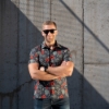 Red and black polyester button up tee shirt with flowers and FN firearms - lifestyle