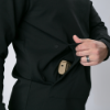 Side view of Concealment Hoodie. A man opens his pocket to reveal a pistol holstered at the waist using a tactical belt, demonstrating effective concealed carry layering